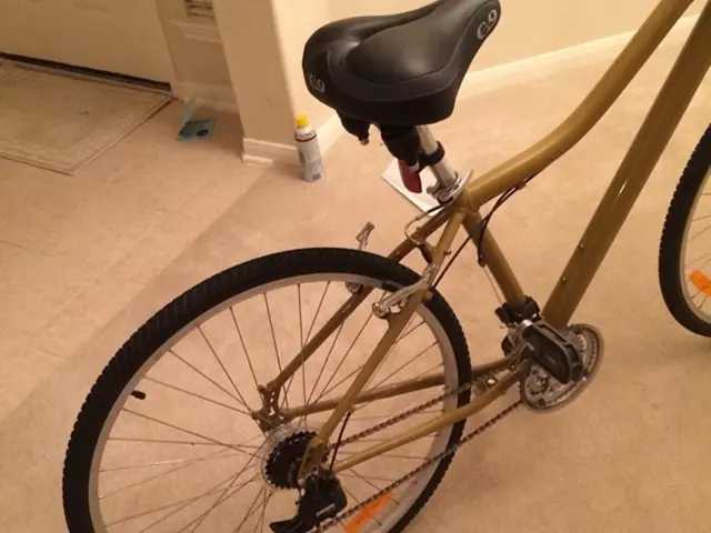 In this image we can see cycle on the floor. In the background there is a mat, door and wall.